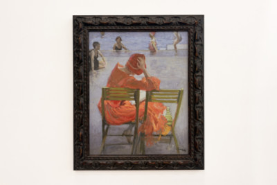 Girl in a red dress reading by a swimming pool