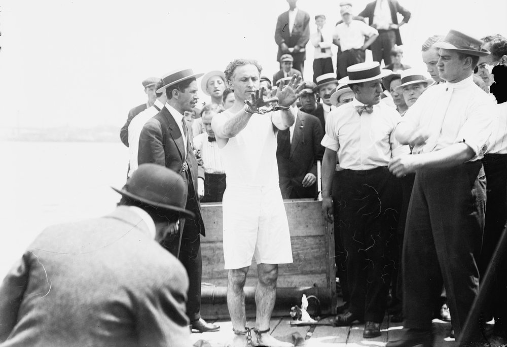Harry Houdini being handcuffed before being nailed into a crate and lowered into New York Bay, 1912 by George Grantham Bain