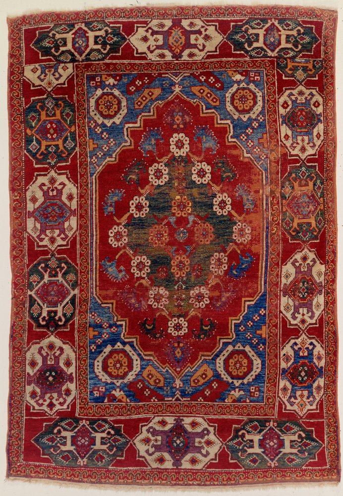 A Transylvanian Rug with Floral Motifs on a Brick Red Background