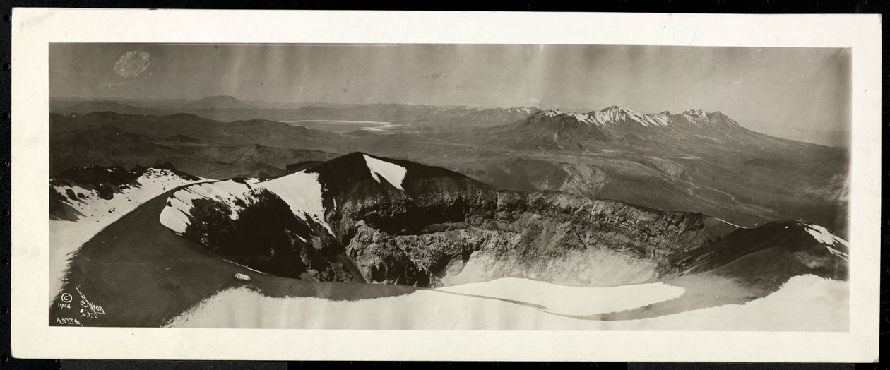 Panoramic view from above of a range of snowcapped mountains, and what appears to be the rim of a volcano, presumably on or near the Panama Canal, 1913 by Byron Company