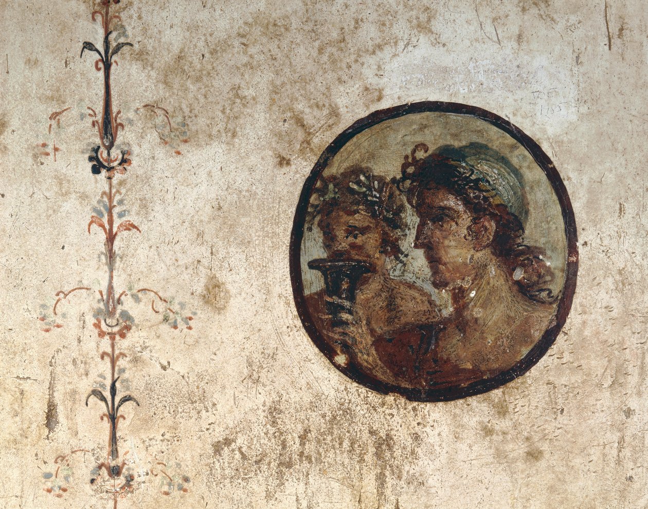 Interior of a Room with Wall Frescoes from the Roman Period, Style III, in the House of Corieo Tiburtino in Pompeii: Part of a Vine and a Tondo with Two Male Heads by Unknown