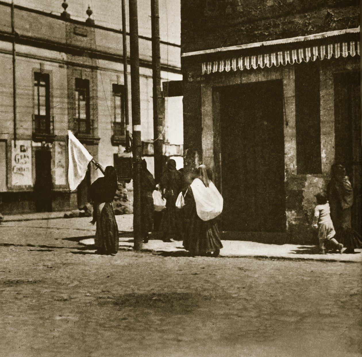 Women walking in the streets under the cover of a white flag during 