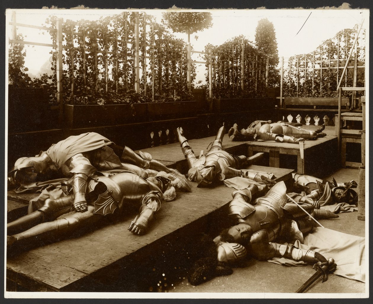 Six Male Models as Ancient Warriors Dressed in Armor Pretending to be Dead by Alphonse Maria Mucha