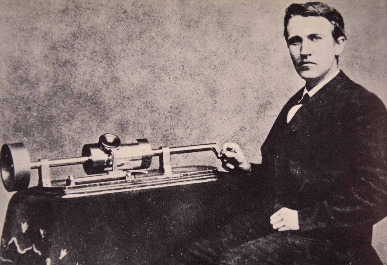 Thomas A. Edison sitting by his invention, the Phonograph, 1878 by American Photographer