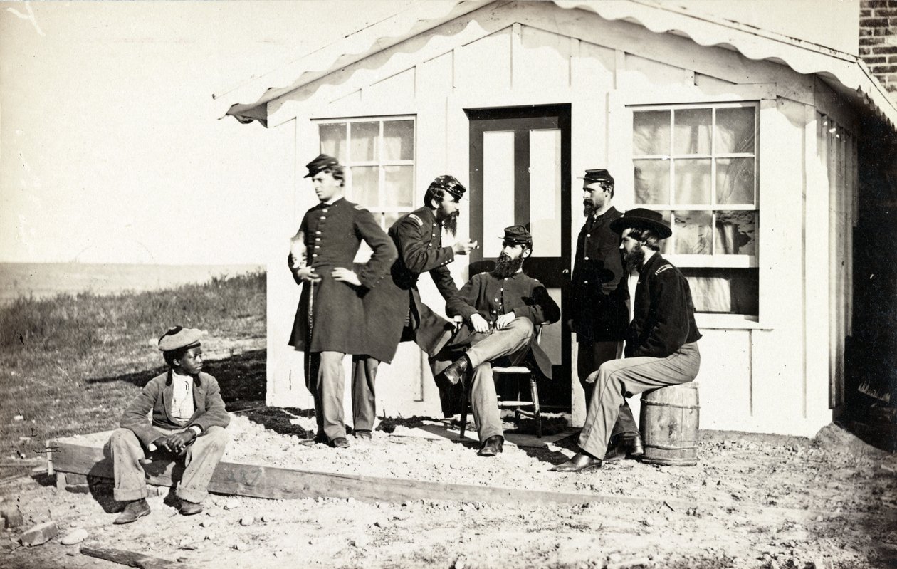 Five Civil War soldiers gathered on dirt porch outside home, African American youth seated near them by American Photographer