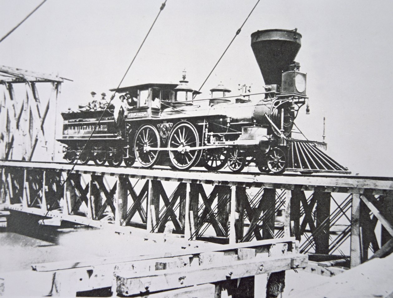 Locomotive of the US Military Railroads (Union Army) crossing trestle bridge over the Potomac River by American Photographer