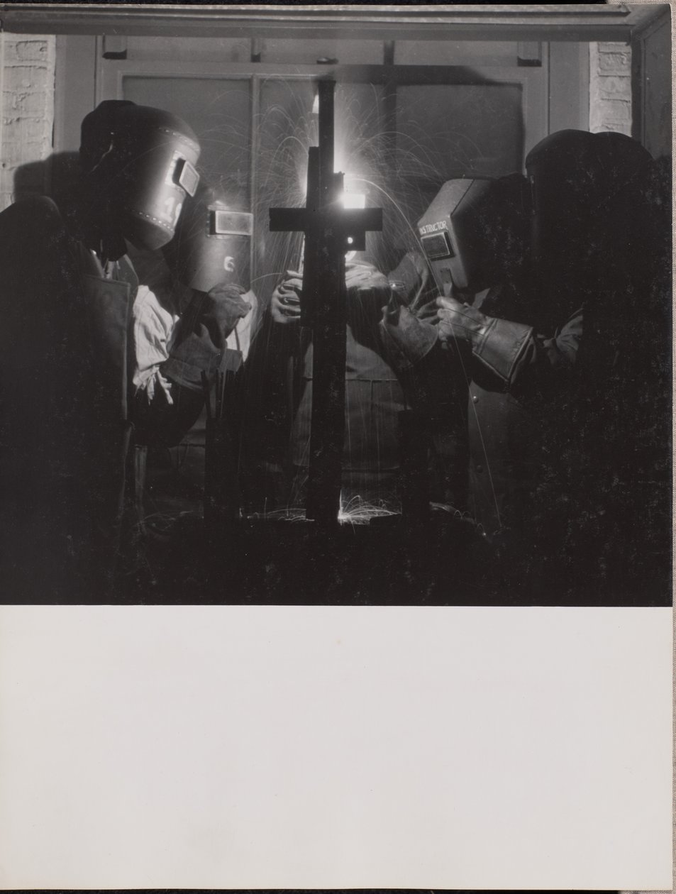 Four men wearing welding helmets welding a piece of metal by Arnold Eagle