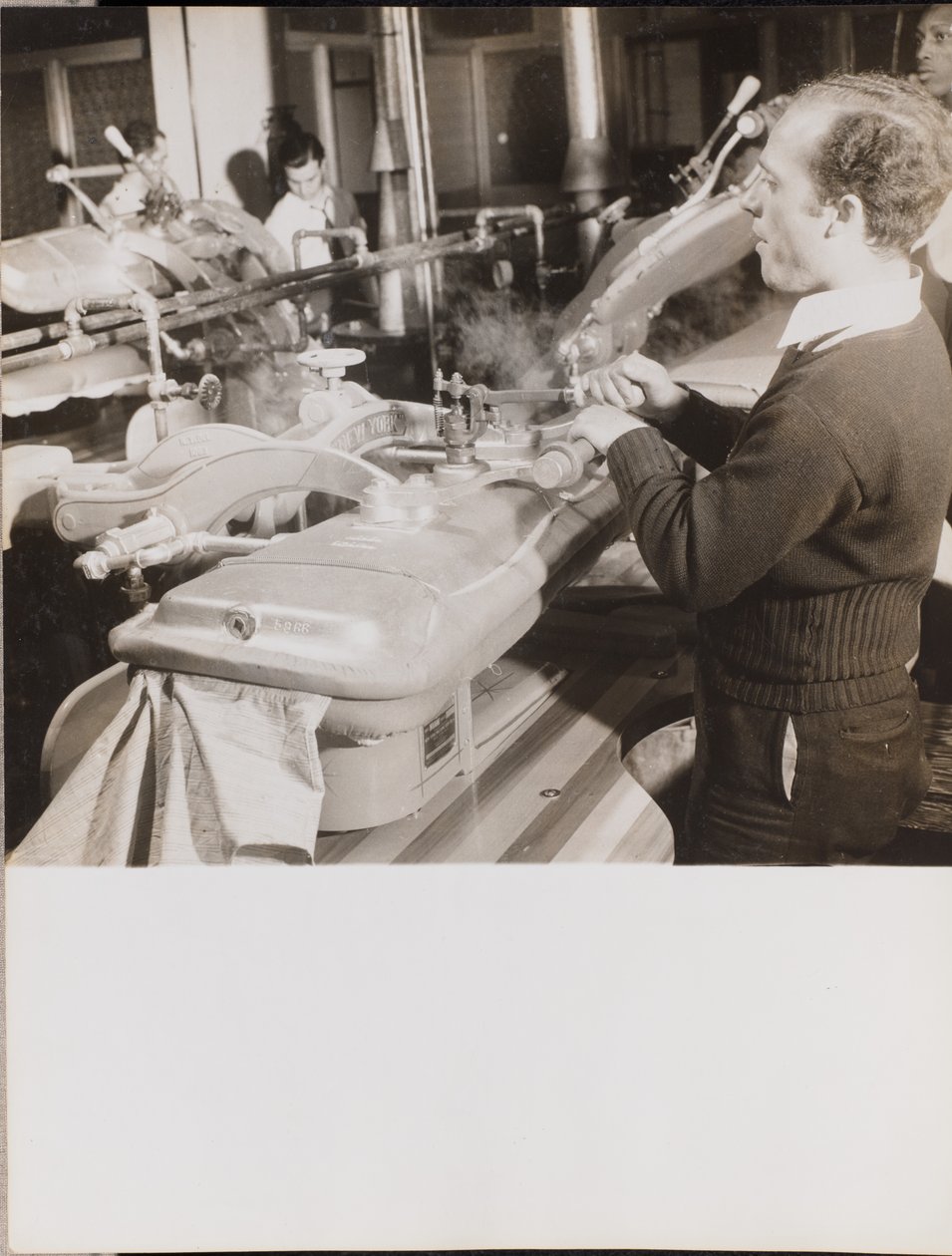 Man Uses a Machine to Press Dresses by Arnold Eagle