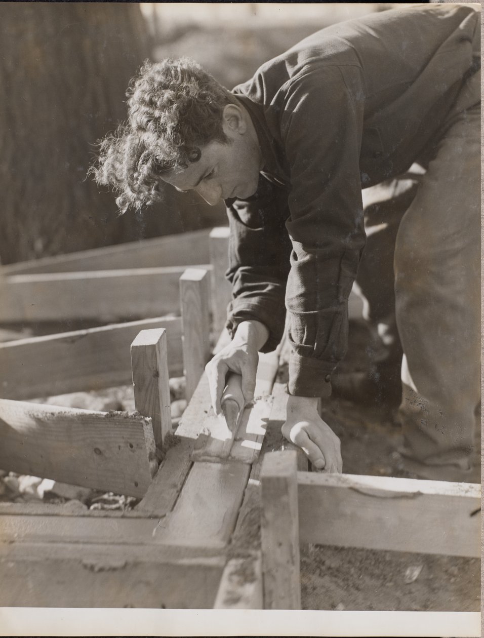 Mason Smooths Cement While Pouring a Foundation by Arnold Eagle