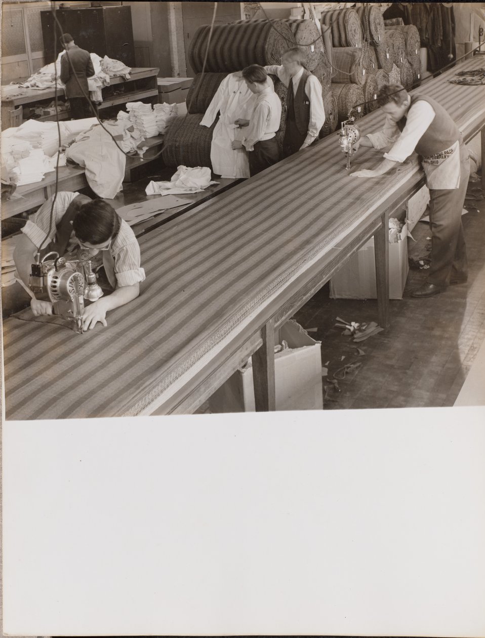 Two Men Wearing Aprons Cut Fabric by Arnold Eagle
