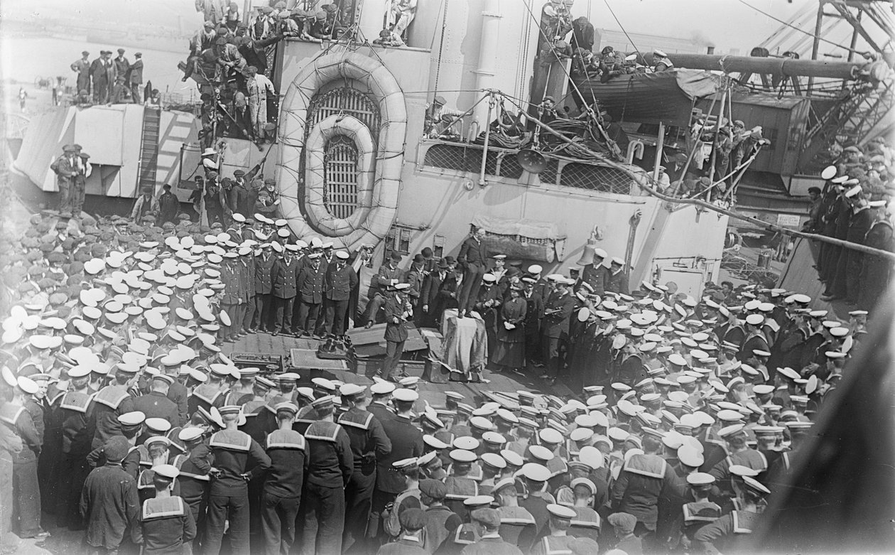 Seamen crowd around Australian Prime Minister William Morris (Billy) Hughes as he addresses them on the deck of HMAS Australia at the dockyard in Devon, England, 21 May 1916 by Australian Photographer
