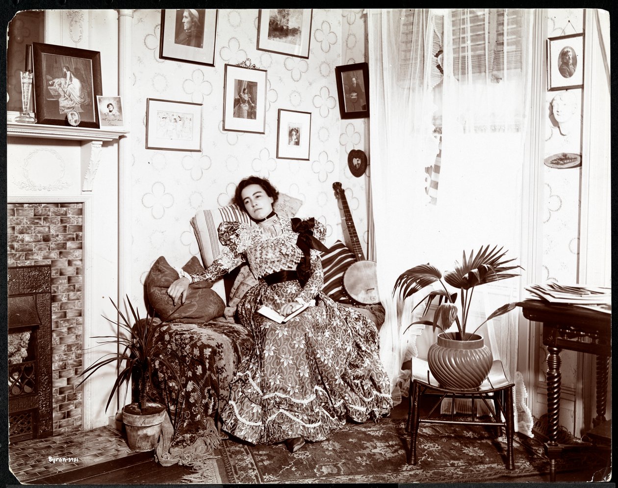 A woman lounging in a chair, reading a book by Byron Company