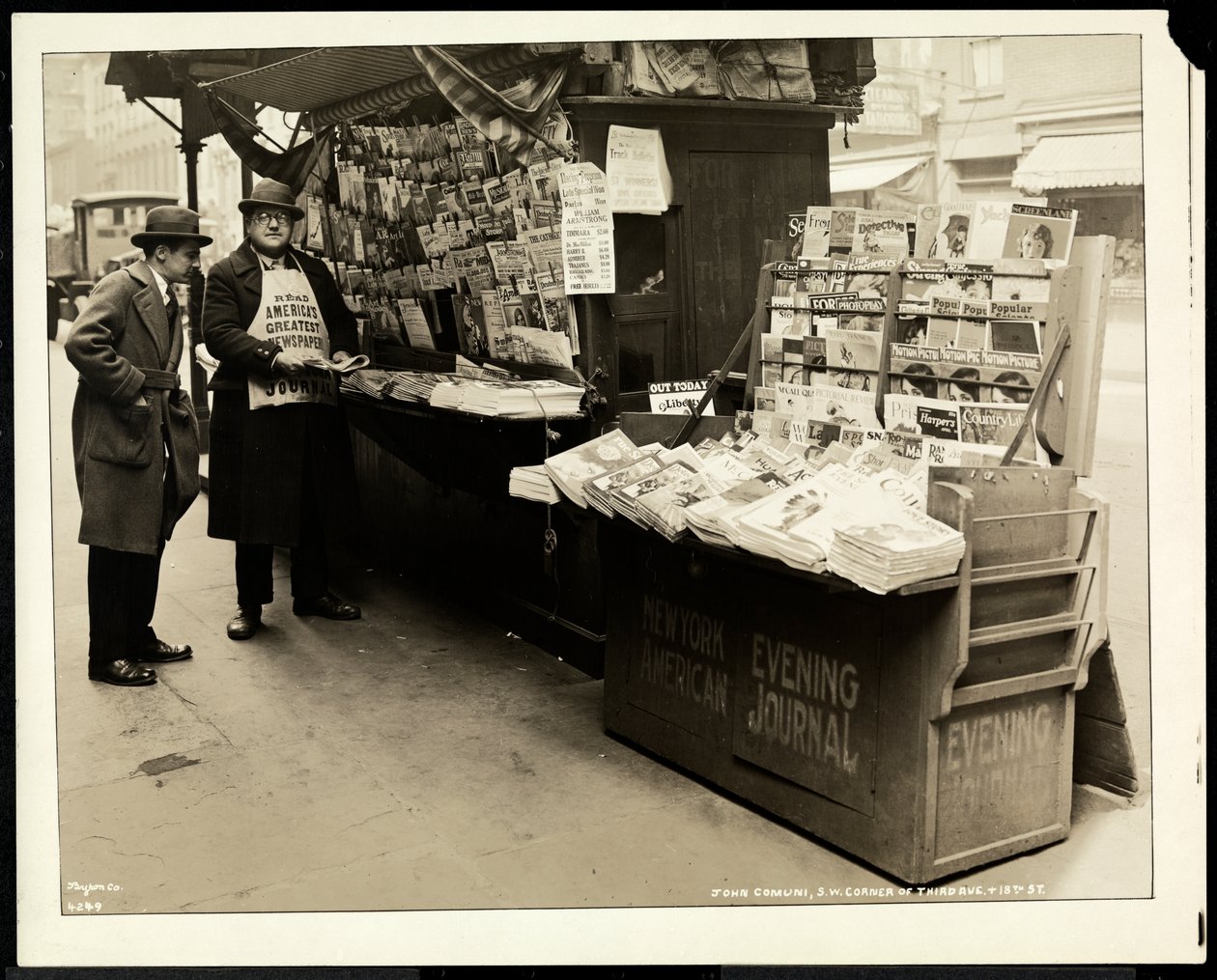 Blind news dealer, John Comuni, at his stand at 3rd Avenue and 18th Street, New York, 1926 by Byron Company