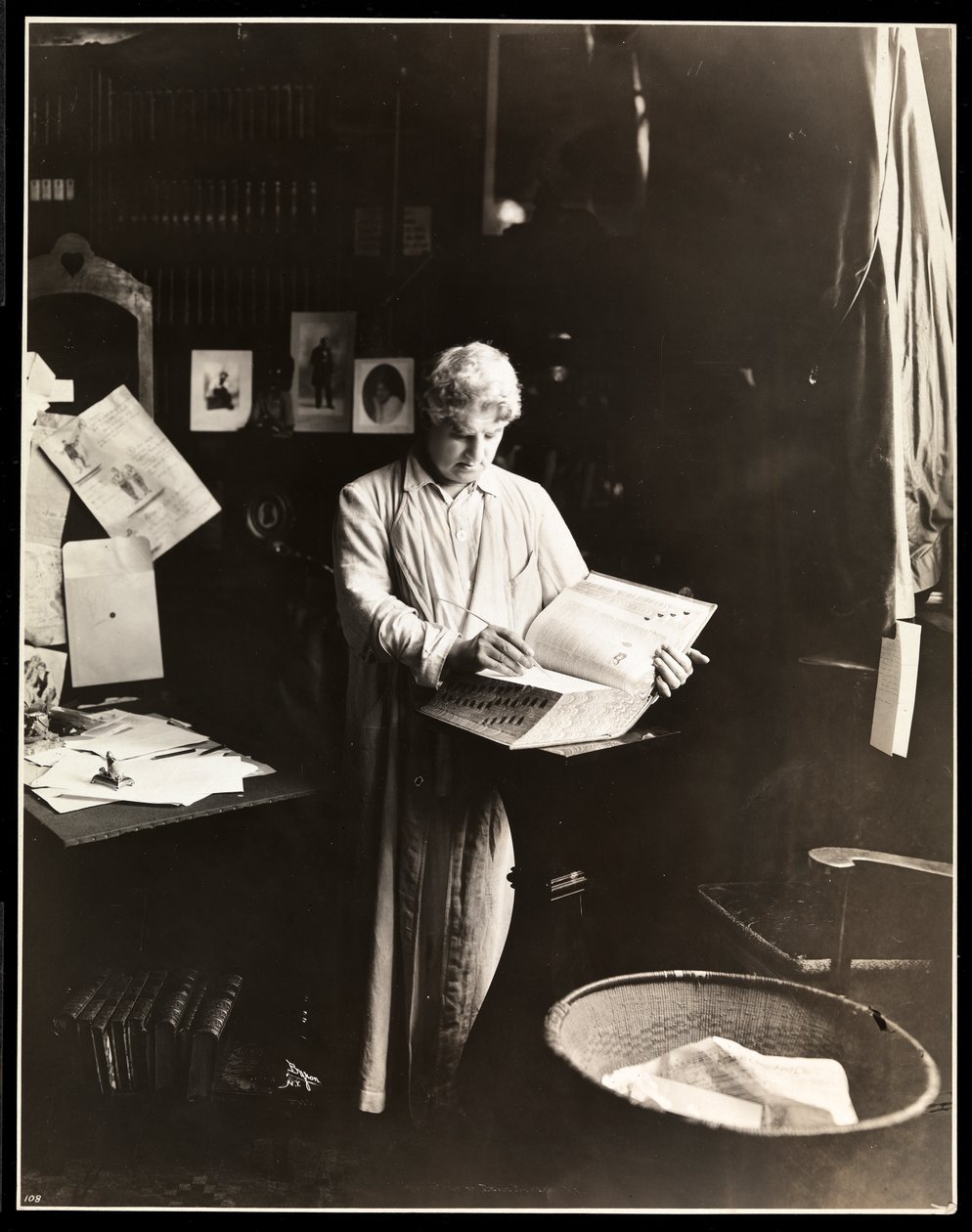David Belasco standing holding a dictionary, after 1909 by Byron Company