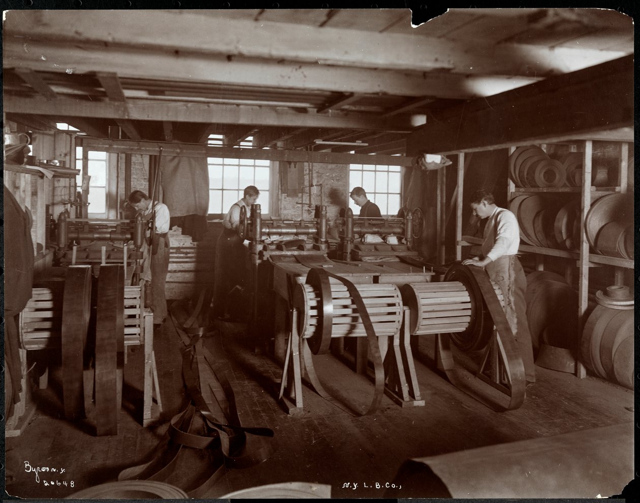 Interior view of men working with leather at the New York Leather Belting Co., New York, 1905 by Byron Company