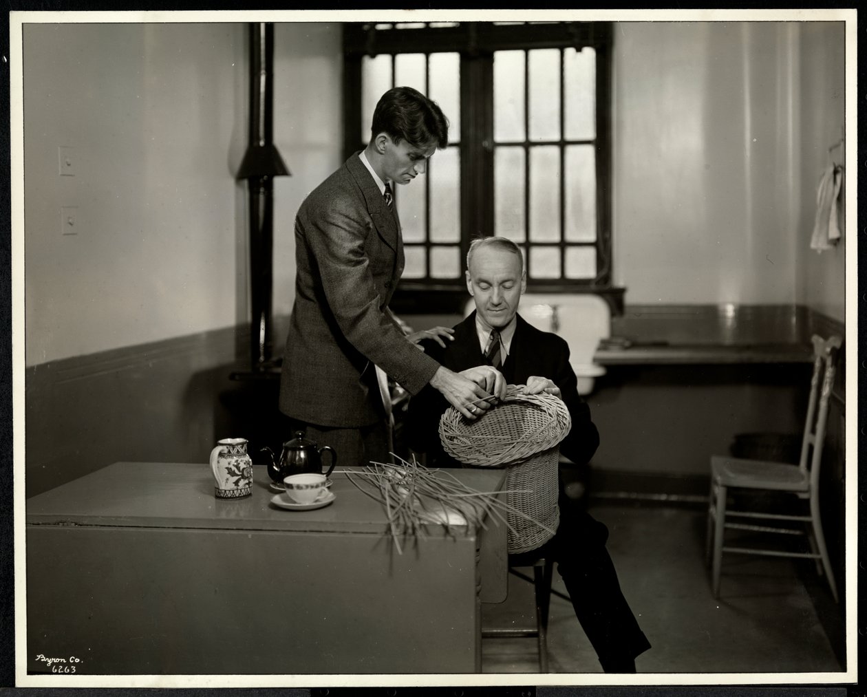 Man teaching another man basketmaking at the New York Association for the Blind, 111 East 59th Street, New York by Byron Company