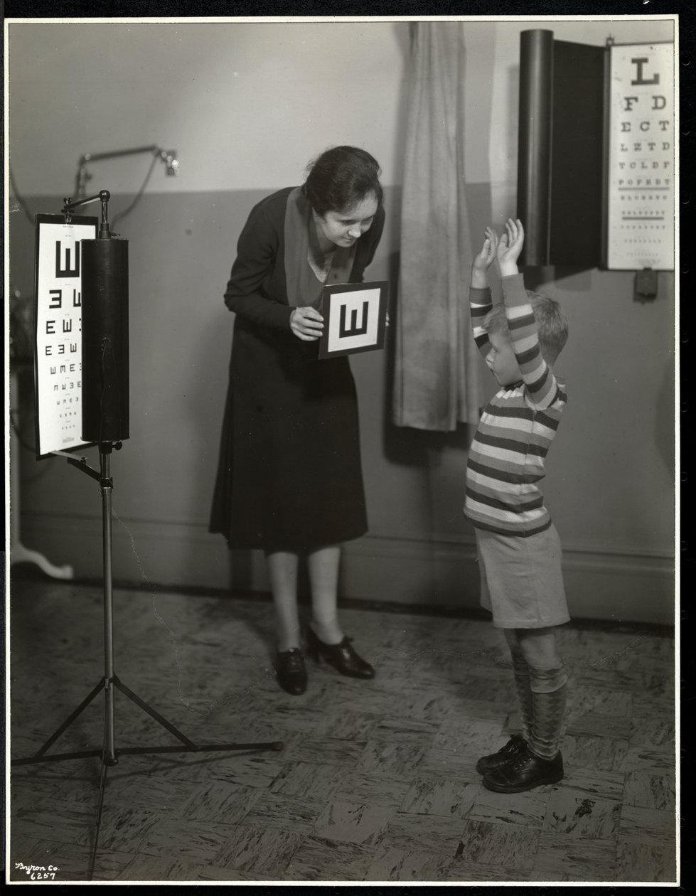 Nurse and a boy patient having an eye test at the New York Association for the Blind, 111 East 59th Street, New York, 1930 by Byron Company