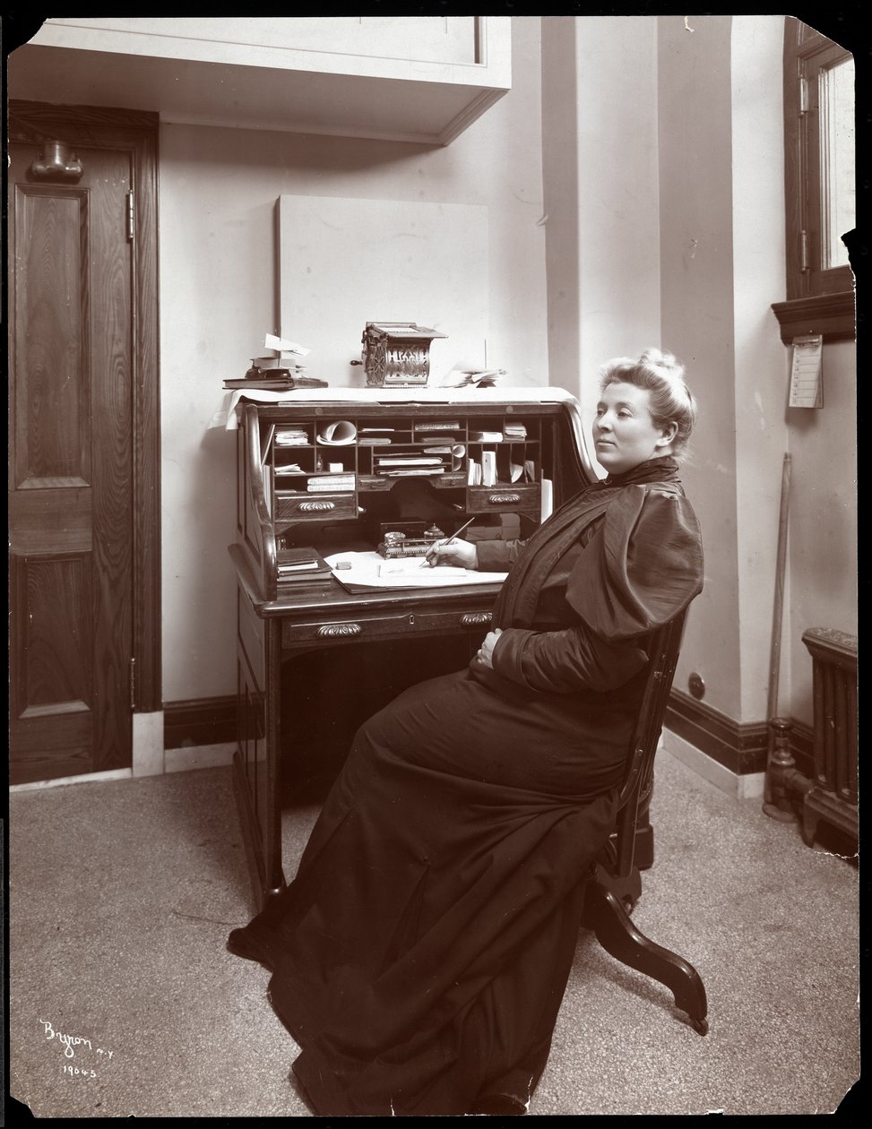 Portrait of an unidentified woman at a desk in an office in New York by Byron Company