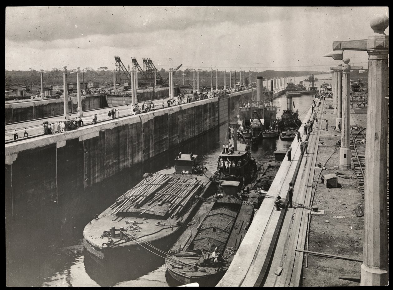 View of dredges and boats at a lock in the Panama Canal during construction by Byron Company