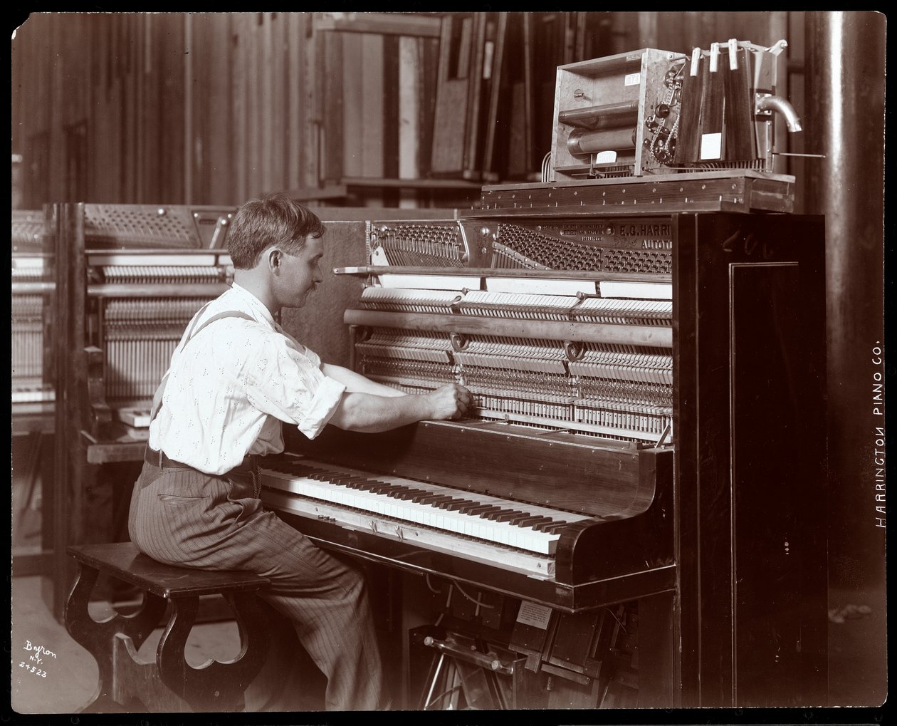 A man working in the Harrington Piano Co. factory, 1907 by Byron Company