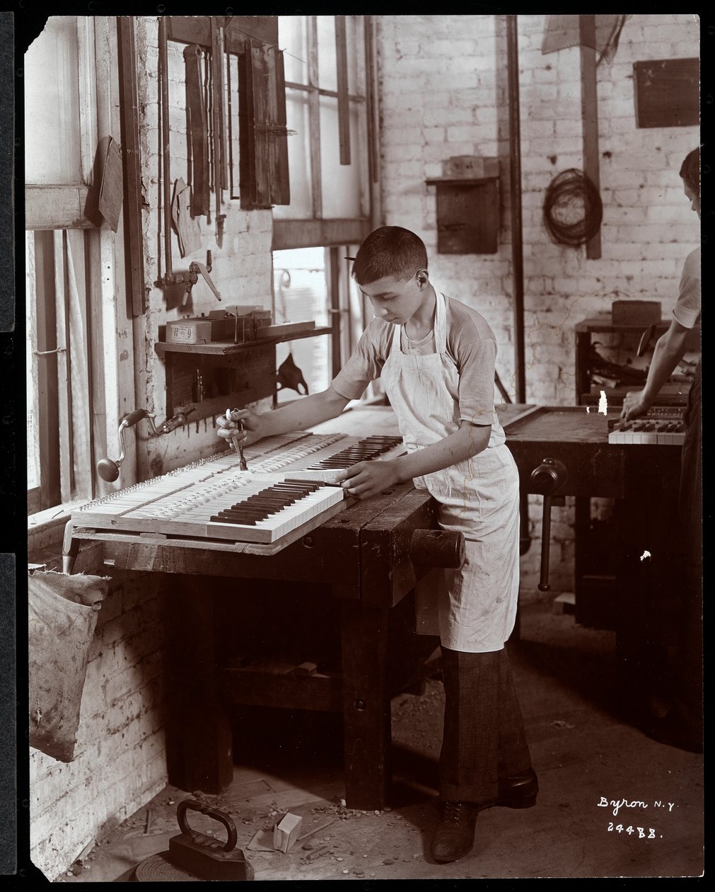 A Young Man Working in the Harrington Piano Co. Factory, 1907 by Byron Company