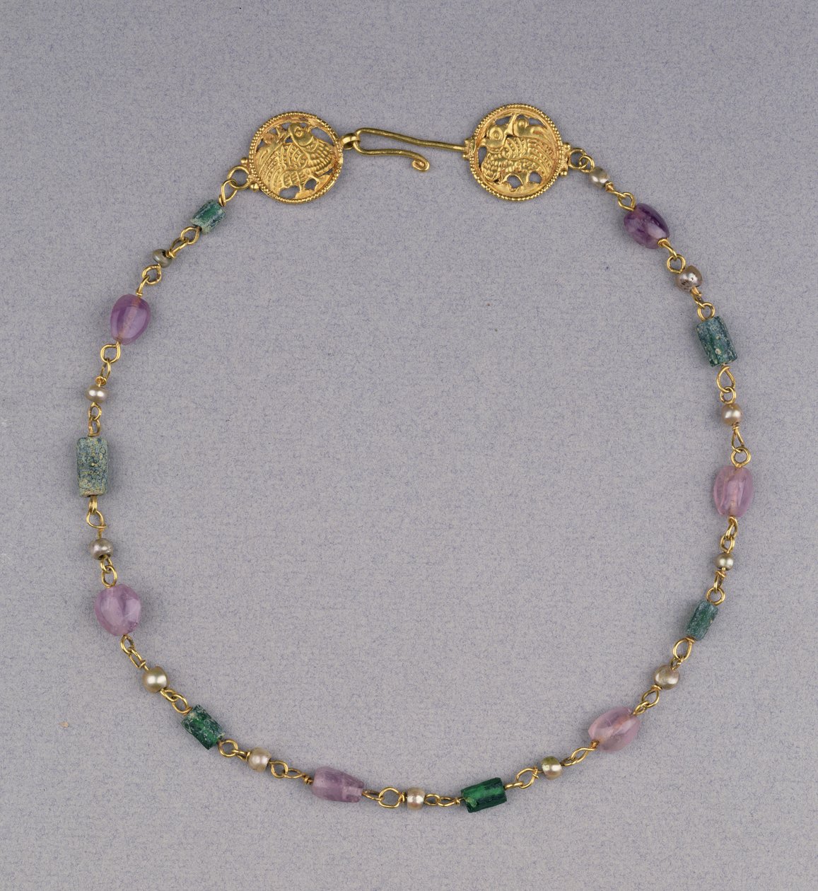 Gold necklace strung with pearls, amethyst and green glass beads with two gold openwork roundels by Byzantine