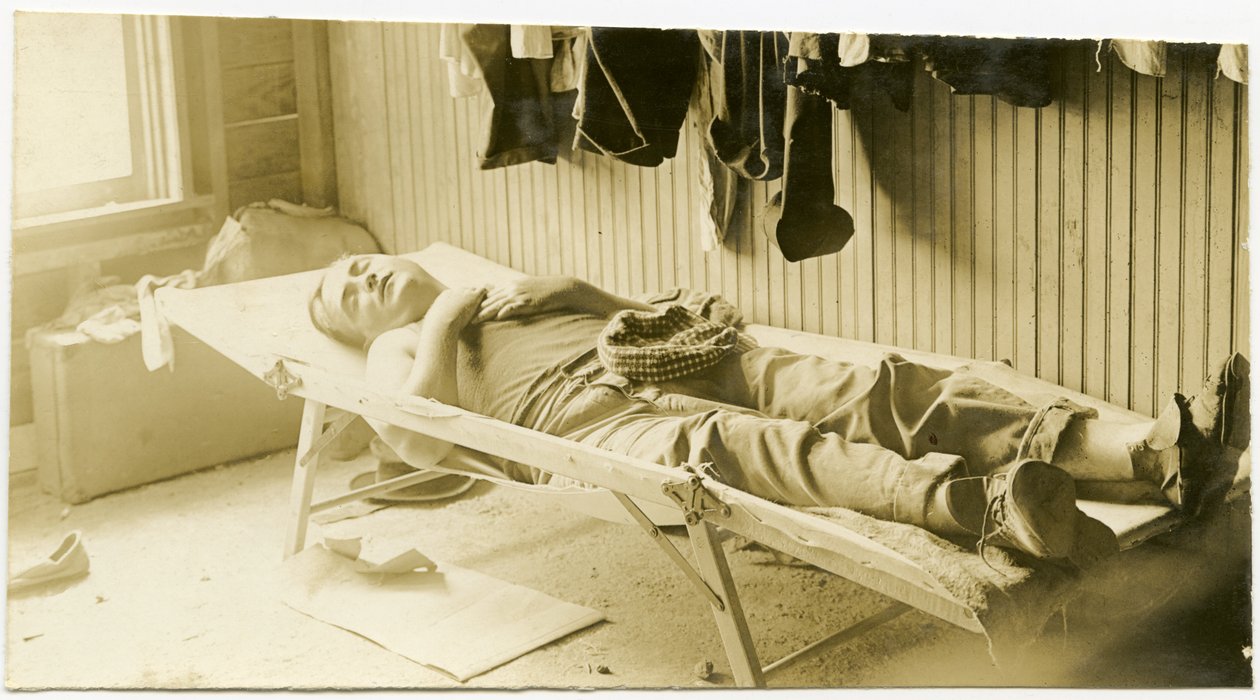 Man Sleeping on a Cot in a Wood Paneled Building by Carl Michel