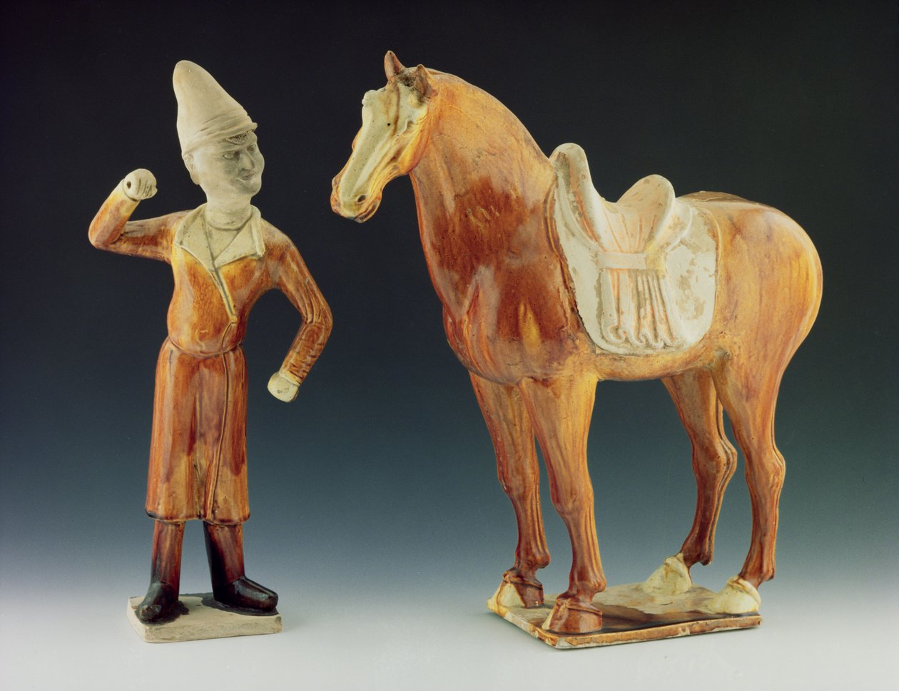 Groom figure wearing a coat and peaked hat with a saddled horse, Tang Dynasty by Chinese School Chinese School