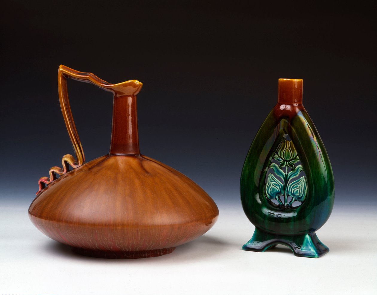 A Linthorpe pottery jug of compressed globular form with streaky caramel, green and crimson glaze and a Linthorpe Pottery vase with pierced flower bud decoration and mottled green, blue and brown glazes by Christopher Dresser