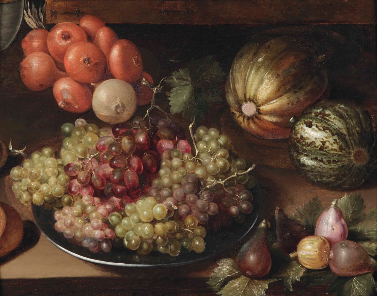 White and red grapes on a pewter plate, a string of onions, two melons and figs, all on a wooden table by Circle of Georg Flegel