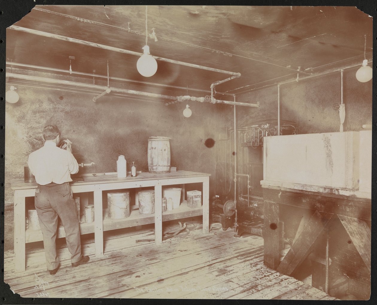 Film laboratories at Carlton Motion Picture Co. with five men and one woman working with film, New York by Company Byron