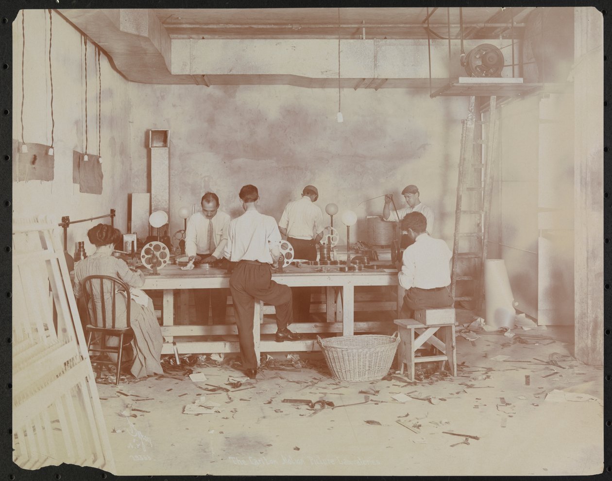 Film laboratories at Carlton Motion Picture Co. with five men and one woman working with film, New York by Company Byron