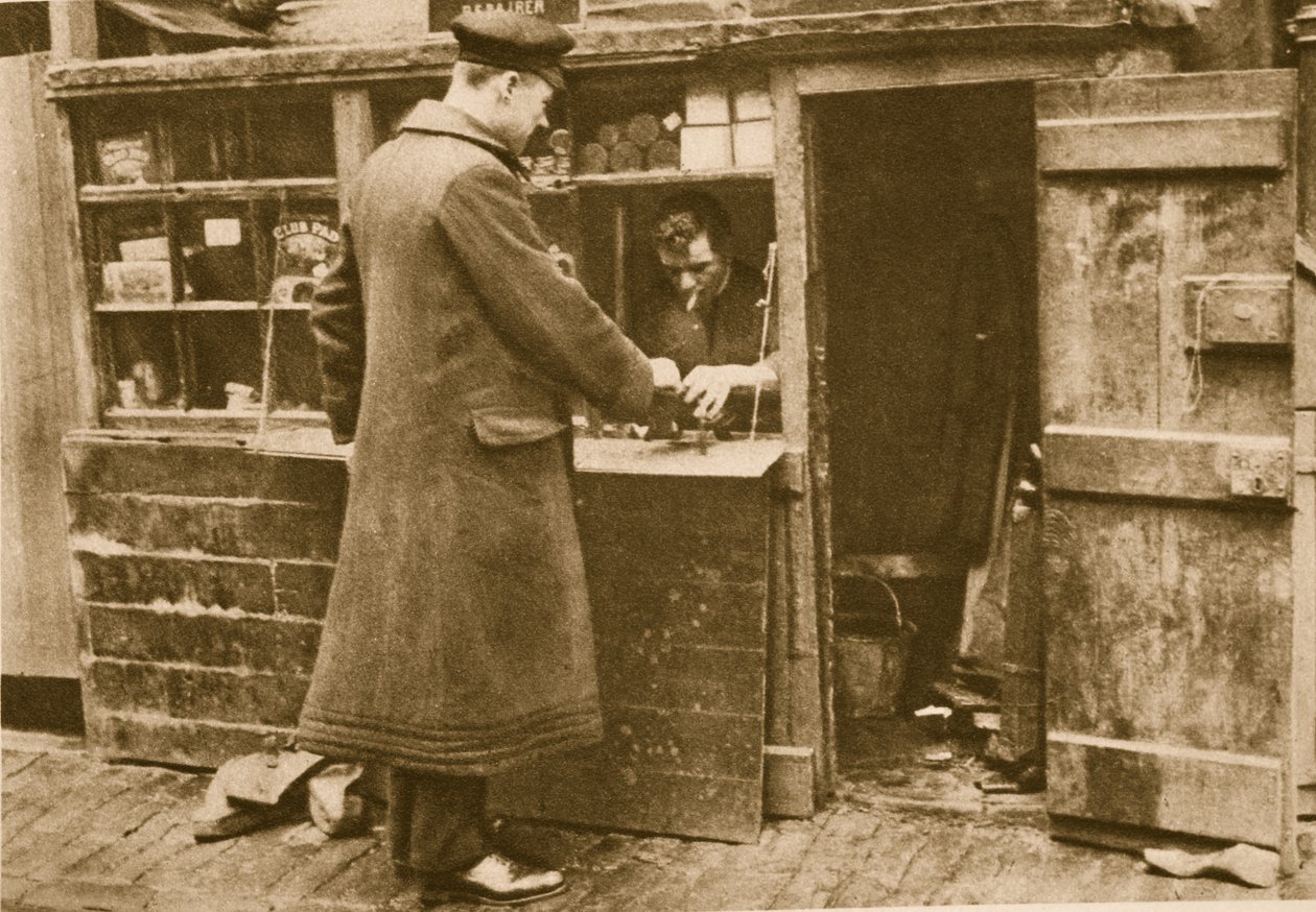 A chauffeur handing in a pair of boots to a cobbler, Mayfair by English Photographer