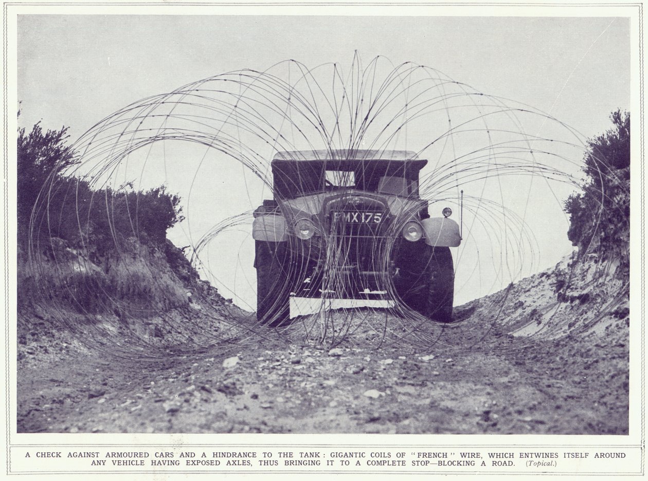 An armoured car is stopped by gigantic coils of French wire blocking the road, from The Illustrated War News, published 22nd November 1939 by English Photographer