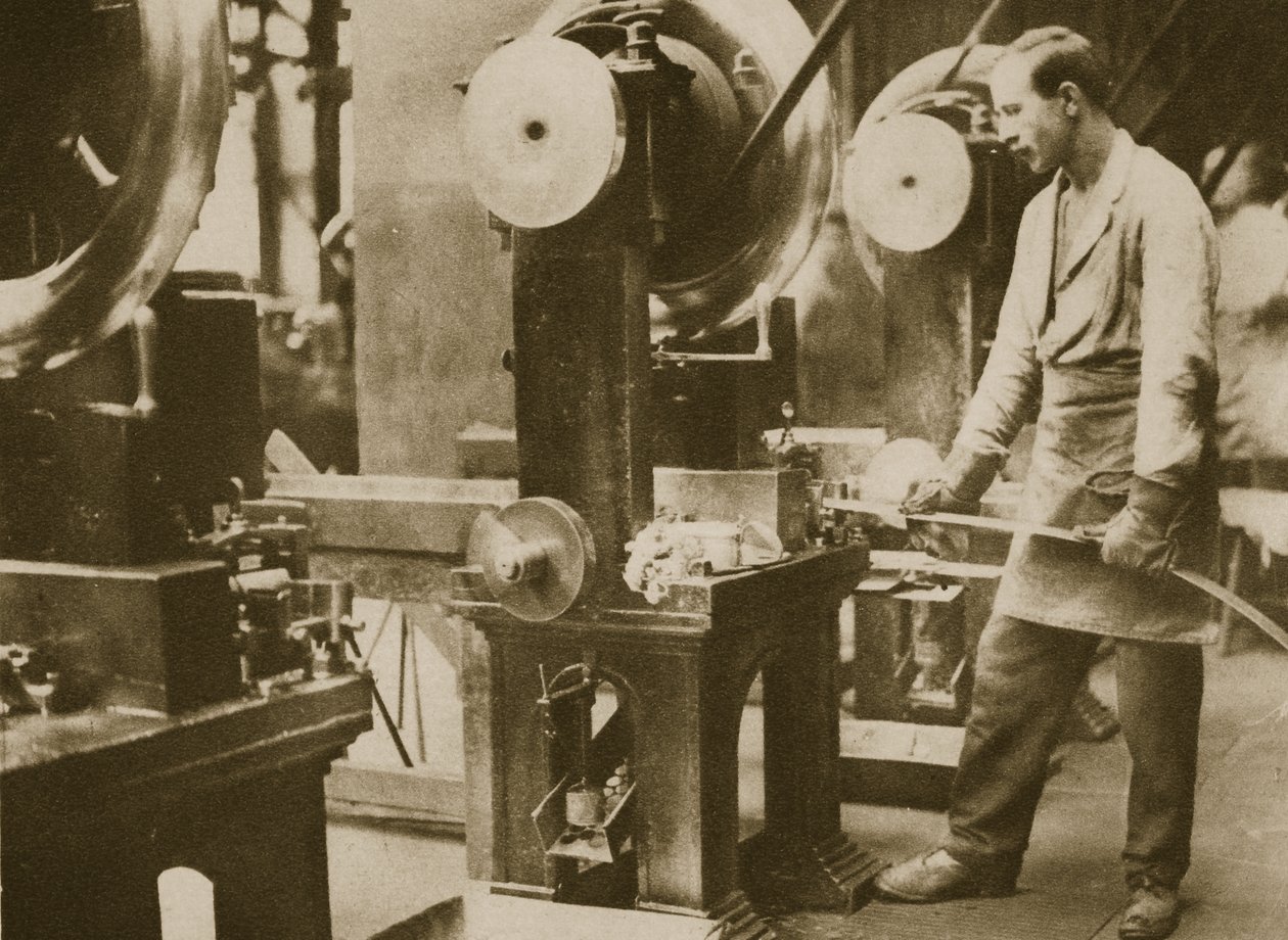 Money making-cutting strips of silver into disks by English Photographer