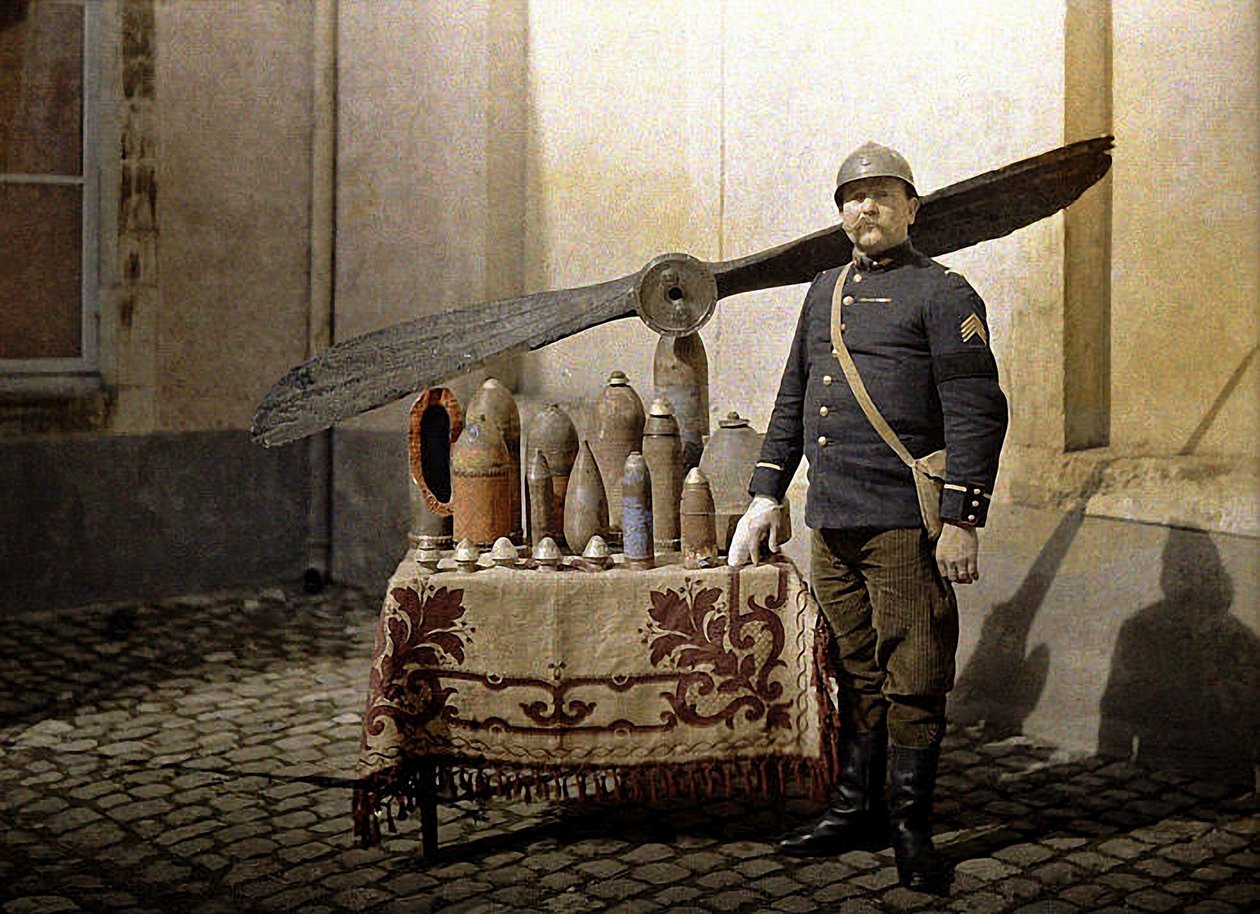 A French soldier next to a table with German grenades and an aircraft propeller, Reims, Marne, 1917 by Fernand Cuville