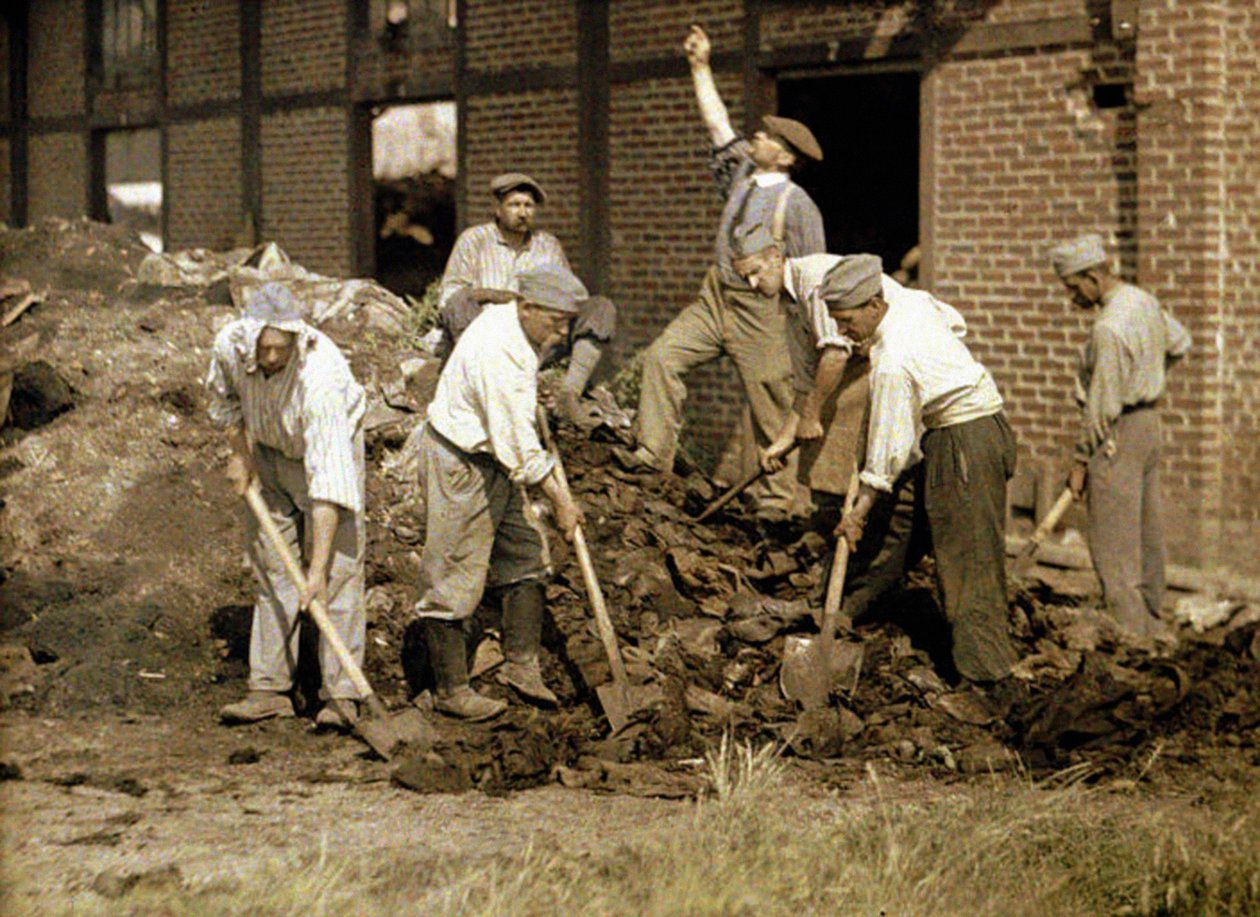 Soldiers working with shovels in the debris of a building, Soissons, Aisne, France, 1917 by Fernand Cuville