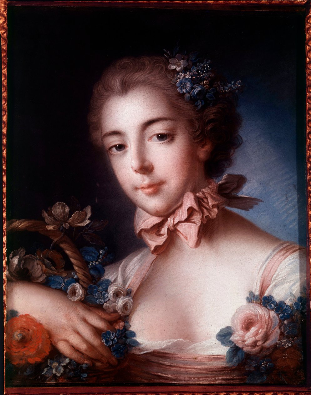 Portrait of a young woman leaning on a basket of flowers by François Boucher