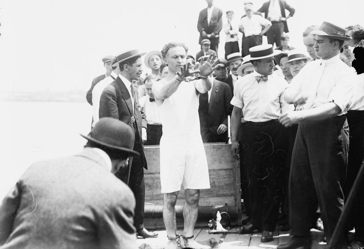 Harry Houdini being handcuffed before being nailed into a crate and lowered into New York Bay, 1912 by George Grantham Bain