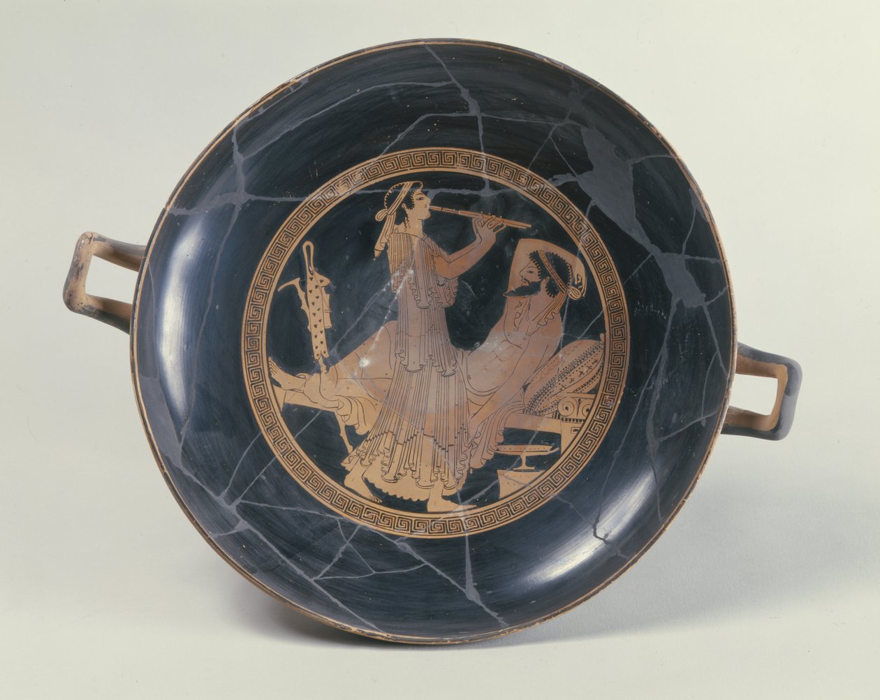 Attic red-figure cup depicting a woman playing a double flute by Greek