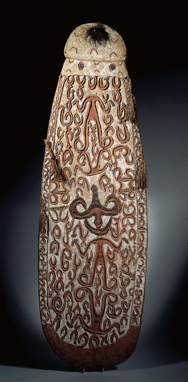 Oval Asmat shield, carved in relief with scrolling ornament incorporating highly stylised figures, plaited tassels to the border by Guinean New