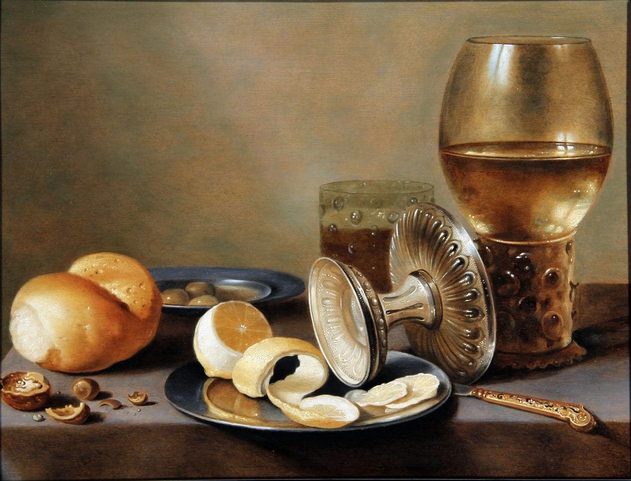 Monochrome Banquet with Two Pewter Dishes, an Overturned Silver Tazza, a Gilt Knife, a Glass with Beer, a Rummer with Wine, a Roll of Bread, Nuts, Olives and a Half Peeled Lemon by Hans van Sant