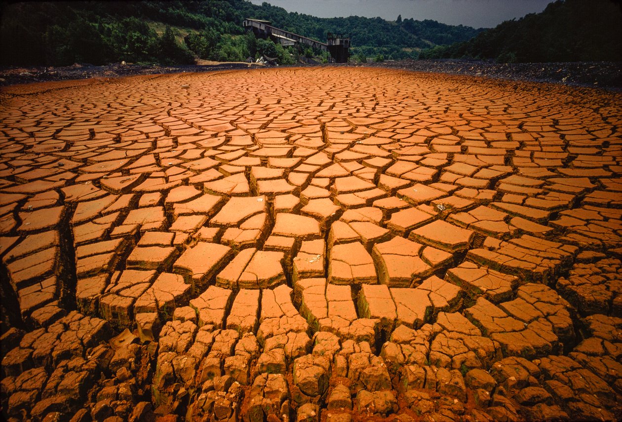 Pond bed left bare after being polluted by a coal mine acid and other waste by James L Stanfield