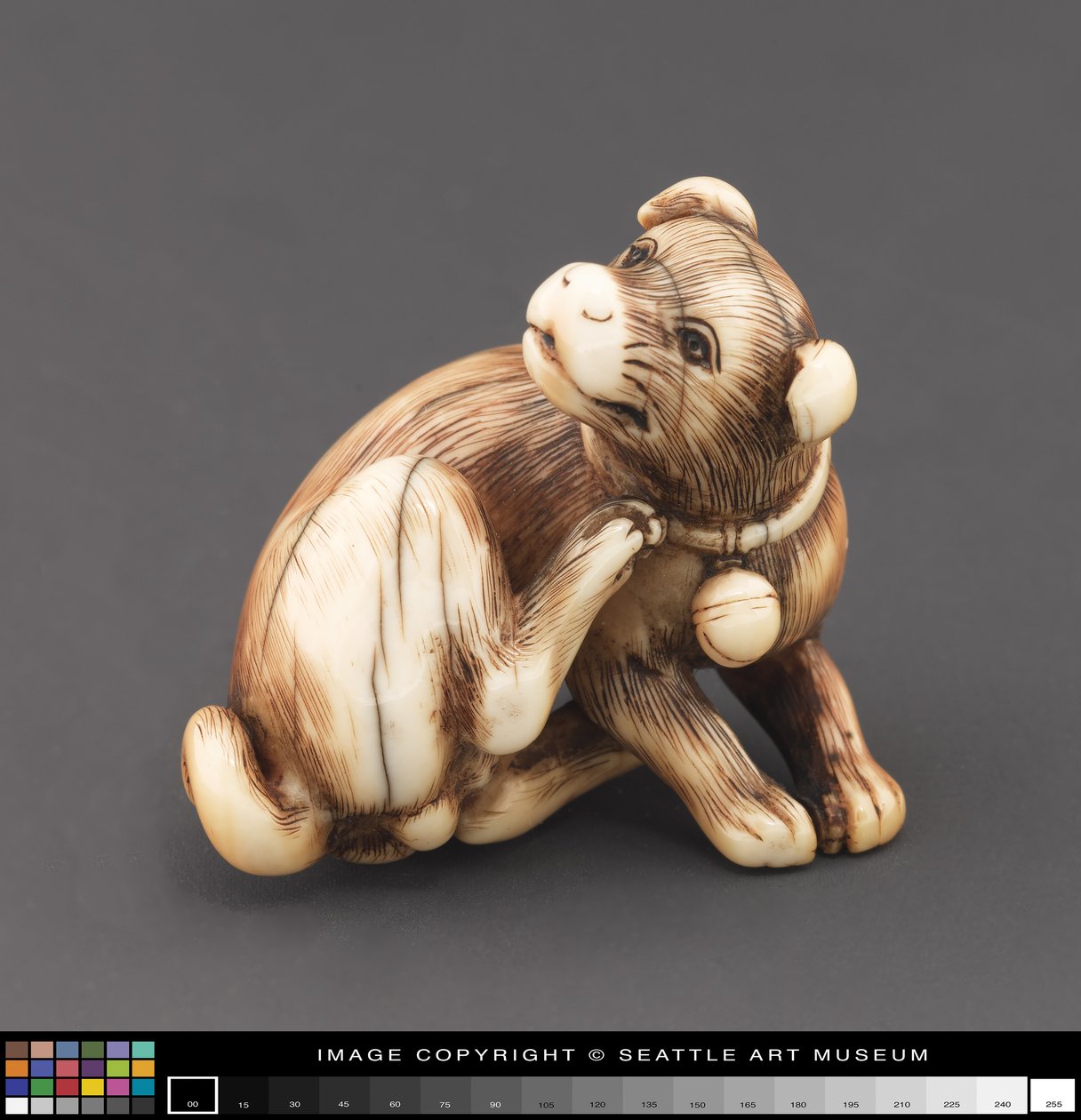 Netsuke modeled as a dog scratching its neck by Japanese School