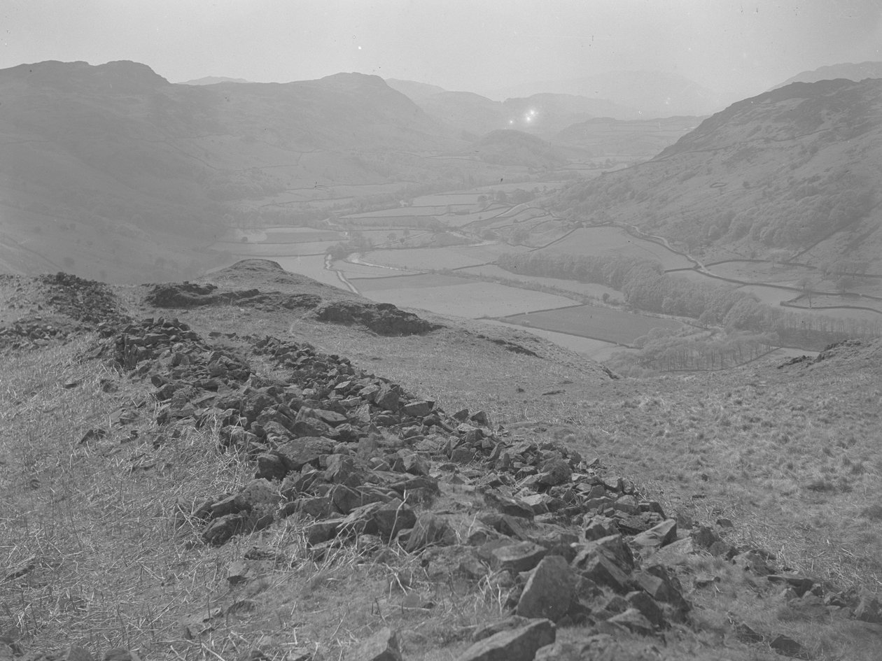 View across an open valley at Hardknott with piles of rocks in the foreground by Joseph Hardman