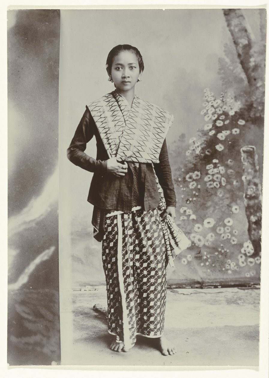 Studio portrait of a young Javanese woman in a sarong with batik motif and a checkered shirt by Kassian Cephas