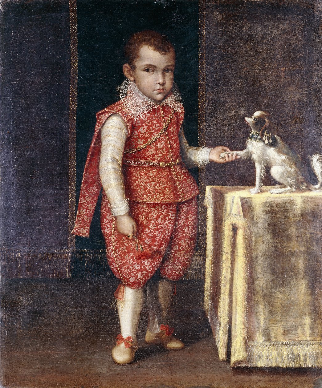 Portrait of a Boy, full-length, wearing a silver-embroidered red costume, holding the paw of a spaniel on a table by Lavinia Fontana