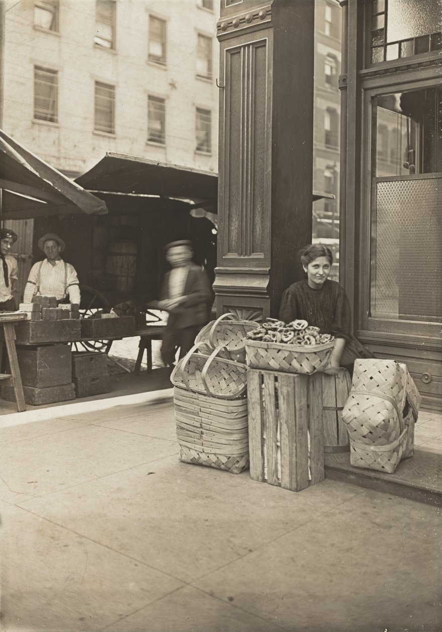 Lena Lochiavo, 11 years old, basket and pretzel seller, at Sixth Street market in front of saloon entrance, Cincinnati, Ohio, August 1908 by Lewis Wickes Hine