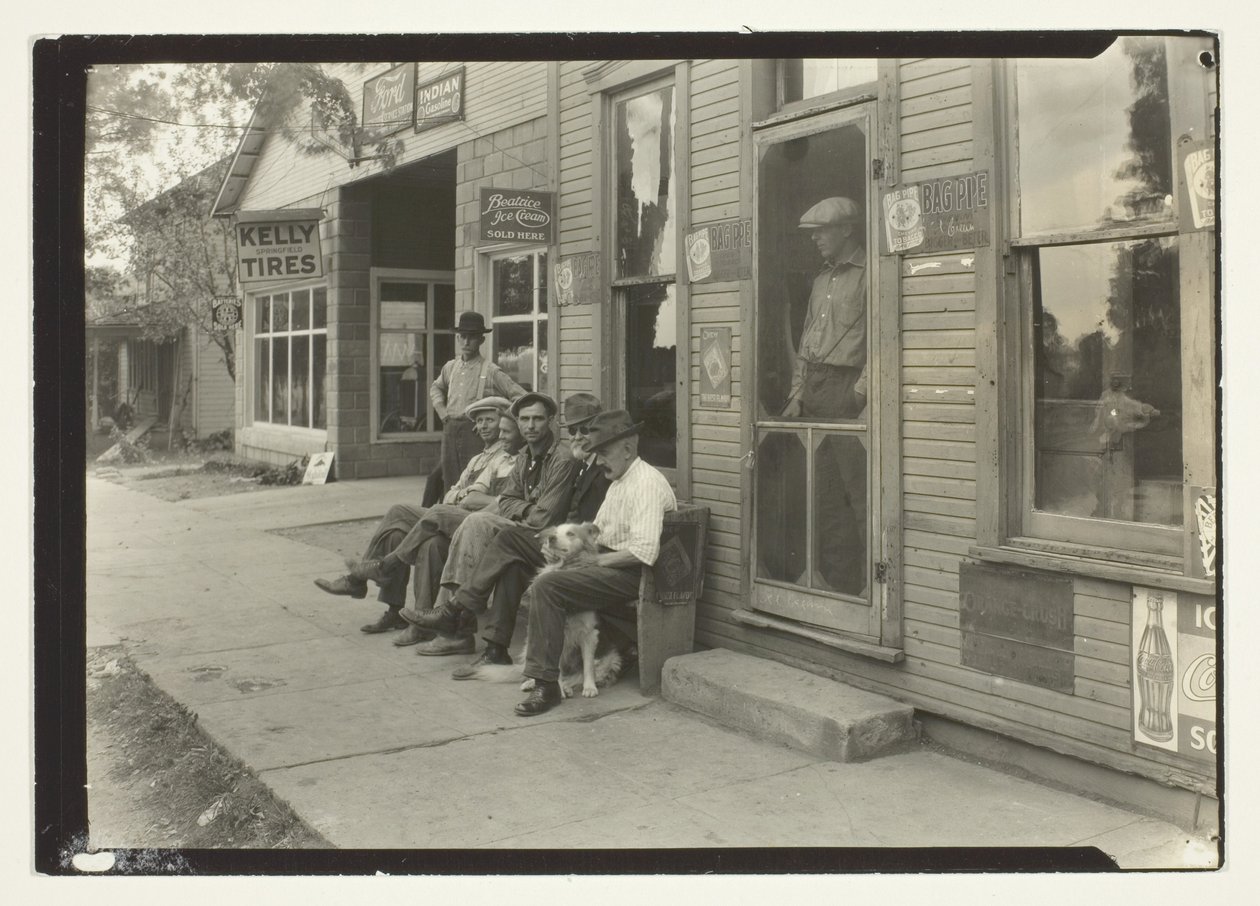 Men With Dog Sitting On Bench In Front Of General Store by Lewis Wickes Hine