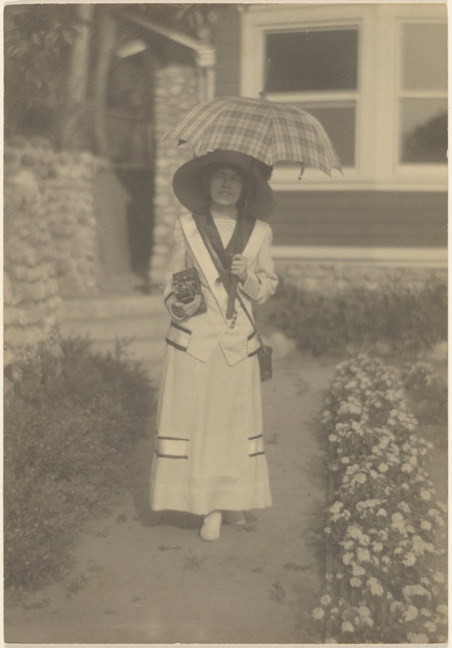 Woman Standing in Front Yard with Camera and Plaid Umbrella by Louis Fleckenstein